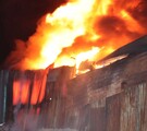 Columna de fuego y humo saliendo del interior de una fábrica de dulces en Zapopan con paredes de lámina alrededor