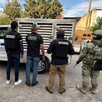 Oficiales de la Fiscalía de Jalisco, policías de investigación y militar del Ejército mexicano parados de espaldas delante de una camioneta de Tlaquepaque
