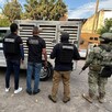 Oficiales de la Fiscalía de Jalisco, policías de investigación y militar del Ejército mexicano parados de espaldas delante de una camioneta de Tlaquepaque