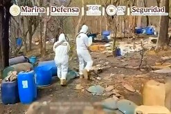Peritos y agentes de la FGR y la Marina con trajes forenses y armas largas en medio de un narcolaboratorio