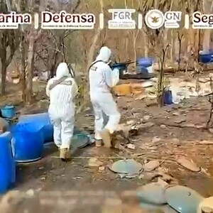 Peritos y agentes de la FGR y la Marina con trajes forenses y armas largas en medio de un narcolaboratorio