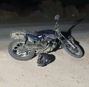 Se observa una motocicleta color negro tirada sobre la carpeta asfáltica.