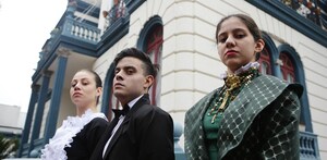 Personas vestidas con temática de una casa tradicional italiana y de fondo la Casa de los Enanos