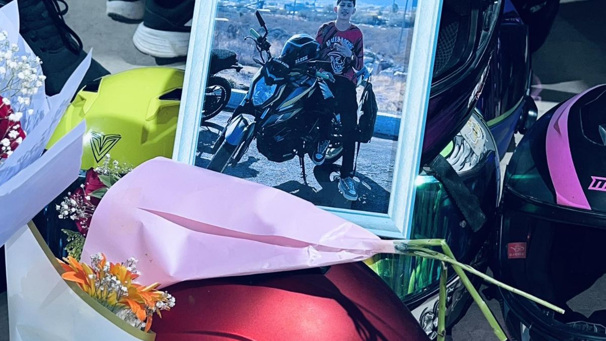 Flores, casco y fotografía de joven de 19 años fallecidos.