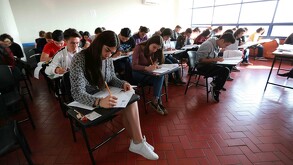 Grupo de jóvenes aspirantes sentados dentro de un salón de clases de la Universidad de Guadalajara presentando el examen de admisión
