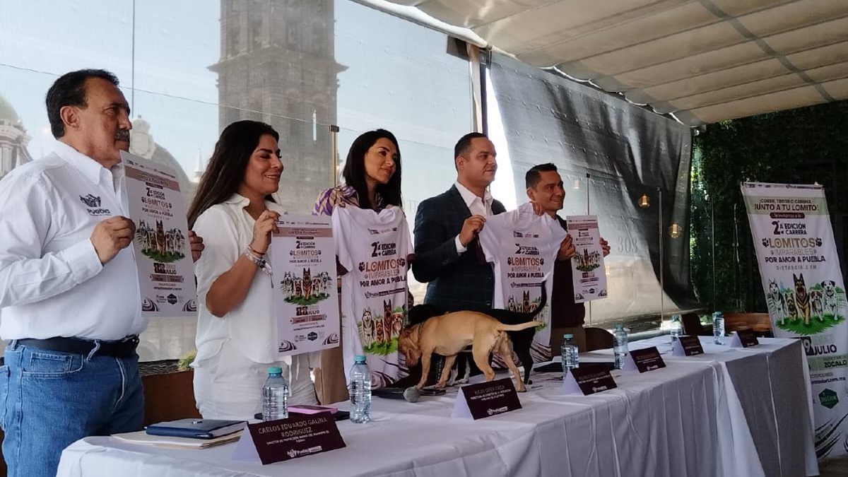 Autoridades en una mesa principal presentan el cartel de la carrera de Lomitos