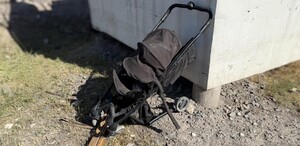Se observa una carriola negra destruida en una zona de piedras.