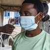 Un funcionario de salud fronterizo en el cruce de Busunga entre Uganda y la República Democrática del Congo toma la temperatura de un viajero