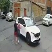 Captura de un video de seguridad que muestra a una mujer siendo llevada a una camioneta por un hombre que le apunta con un arma