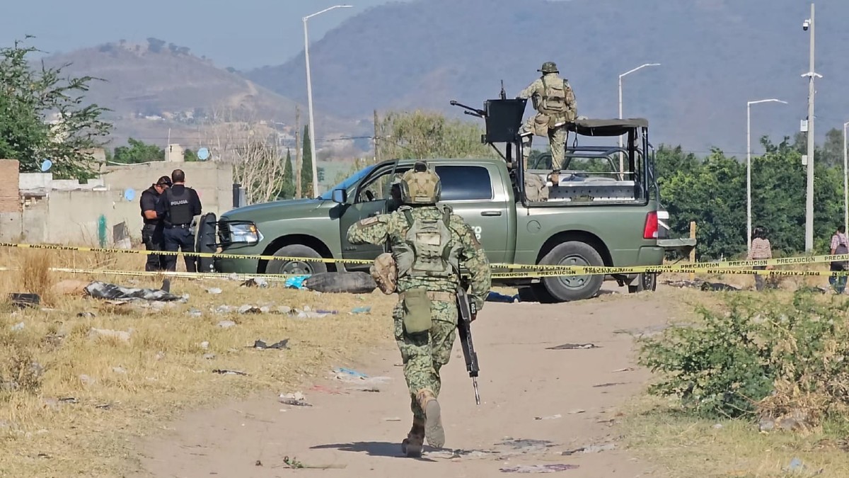 Militares del Ejército Mexicano con una patrulla en un camino de tierra acordonado con oficiales de la Policía de Tlajomulco en el sitio