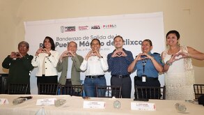 Autoridades de Atlixco hacen un corazón con las manos y de fondo el cartel de la Ruta Pueblo Mágico Atlixco