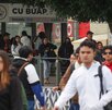 Jóvenes caminando junto a una estación de metrobús.