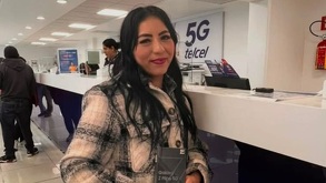 una mujer sostiene un teléfono celular en una tienda