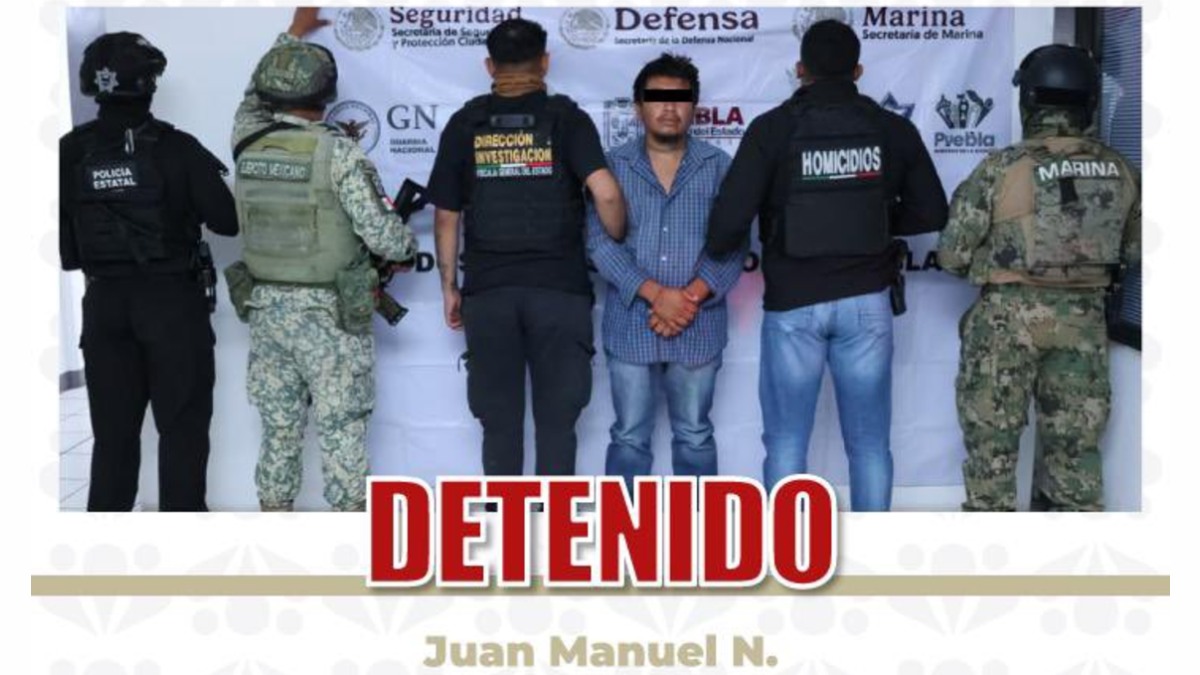 un hombre detenido rodeado de policías y militares