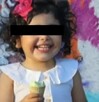 Menor de dos años con vestido, cabello negro rizado y cara censurada