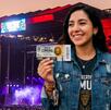 Persona con su boleto y de fondo un escenario del Tecate Comuna