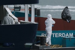 Varias personas con equipo protector retiran desechos del crucero MV Hondius tras su arribo al puerto de Rotterdam, Holanda, el lunes 18 de mayo de 2026.