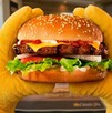 Se observa una hamburguesa con pan, carne de res, tomate, cebolla, queso.
