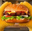 Se observa una hamburguesa con pan, carne de res, tomate, cebolla, queso.