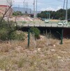 Se observa un puente y hay varios automóviles circulando en la vialidad.