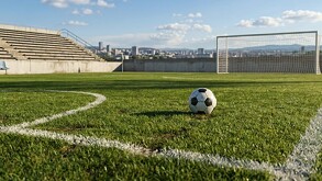 Se observa una cancha de futbol con un balón en medio.