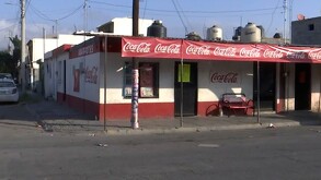 Se observa una fachada de una tienda de abarrotes y el anuncio de Coca Cola.
