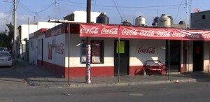Se observa una fachada de una tienda de abarrotes y el anuncio de Coca Cola.