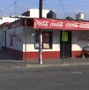 Se observa una fachada de una tienda de abarrotes y el anuncio de Coca Cola.