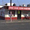 Se observa una fachada de una tienda de abarrotes y el anuncio de Coca Cola.