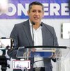 Hombre vestido de traja hablando frente a un micrófono desde la Fiscalía de Oaxaca.
