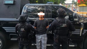 Hombre detenido, policías de Jalisco a los lados