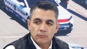 Hombre con semblante serio mirando hacia abajo.