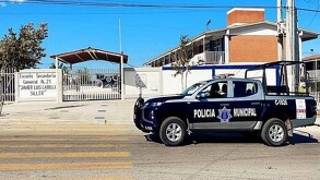 Se observa una fachada de un lugar en color blanco con letras que dicen Escuela Secundaria General número 21 Javier Luis Cabello Siller.