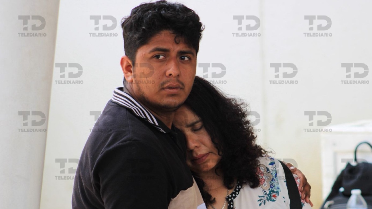 Madre e hijo lloran y se abrazan tras enterarse de la muerte de un familiar.