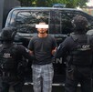 Hombre detenido, policías de Jalisco a los lados
