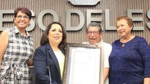 Autor del libro recibe premio en su presentación del libro, acompañado de autoridades en el Congreso del Estado de Puebla