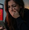 Mujer ve su celular con cara de asombro porque fue estafada en el Hot Sale 2026