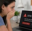 Mujer con cara de preocupación porque acaba de ser estafada en un sitio web falso