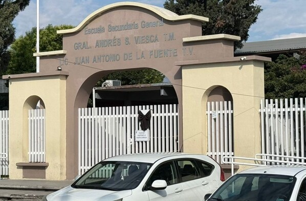 Se observa una fachada de un lugar con letras que dice Secudnaria Andrés S. Viesca.