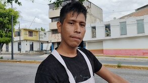 Comerciante transita por las calles vendiendo piñas con mandil rosado