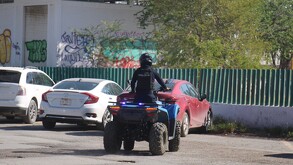 Hombre montando cuatrimoto con uniforme de la Policía
