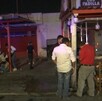 Se observa a varias personas afuera de un establecimiento; es de noche.