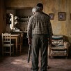 Se observa un padre canoso y una persona de frente que trae un bate de béisbol en las manos.