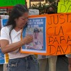 Madre de David Genaro Escalante Reyes durante protesta con carteles y fotos de su hijo desaparecido en calles de Guadalajara