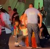 Se observa a varias personas y niños en medio de la calle, hay un señor tendido en el suelo.