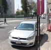 Auto blanco estacionado en zona de parquímetros frente a un hospital en Puebla.