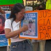 Madre de David Genaro Escalante Reyes durante protesta con carteles y fotos de su hijo desaparecido en calles de Guadalajara
