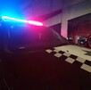 Patrulla de la Policía Municipal de Guadalajara estacionada a las afueras de un con la sirena encendida.