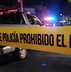Calle acordonada por una cinta policiaca amarilla con patrullas de la Policía de Guadalajara desenfocadas en el fondo