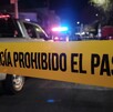 Calle acordonada por una cinta policiaca amarilla con patrullas de la Policía de Guadalajara desenfocadas en el fondo